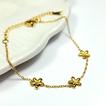 Plona aukso spalvos apyrankė su 3 gėlytėmis