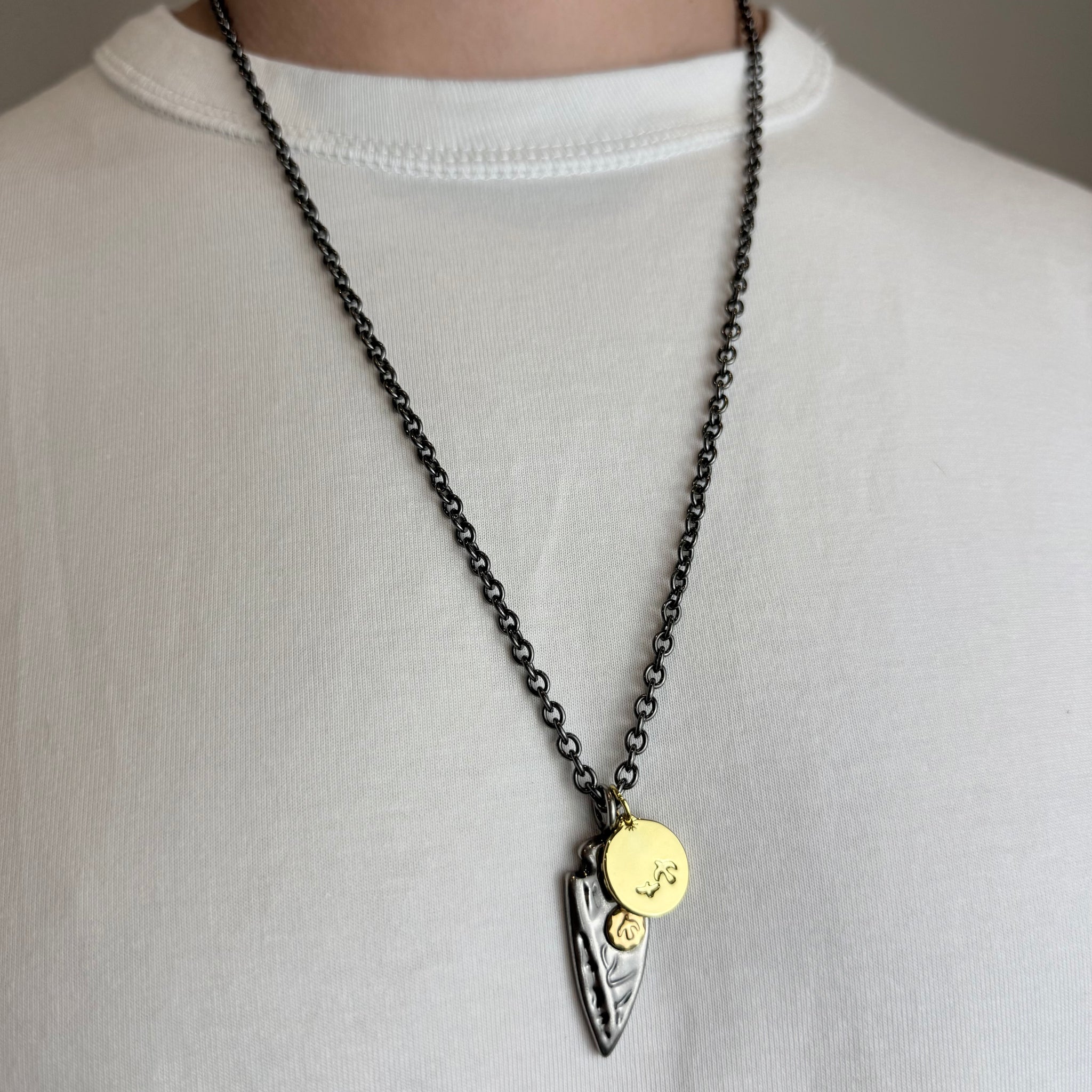 Tamsi grandinėlė su stilizuota plunksna