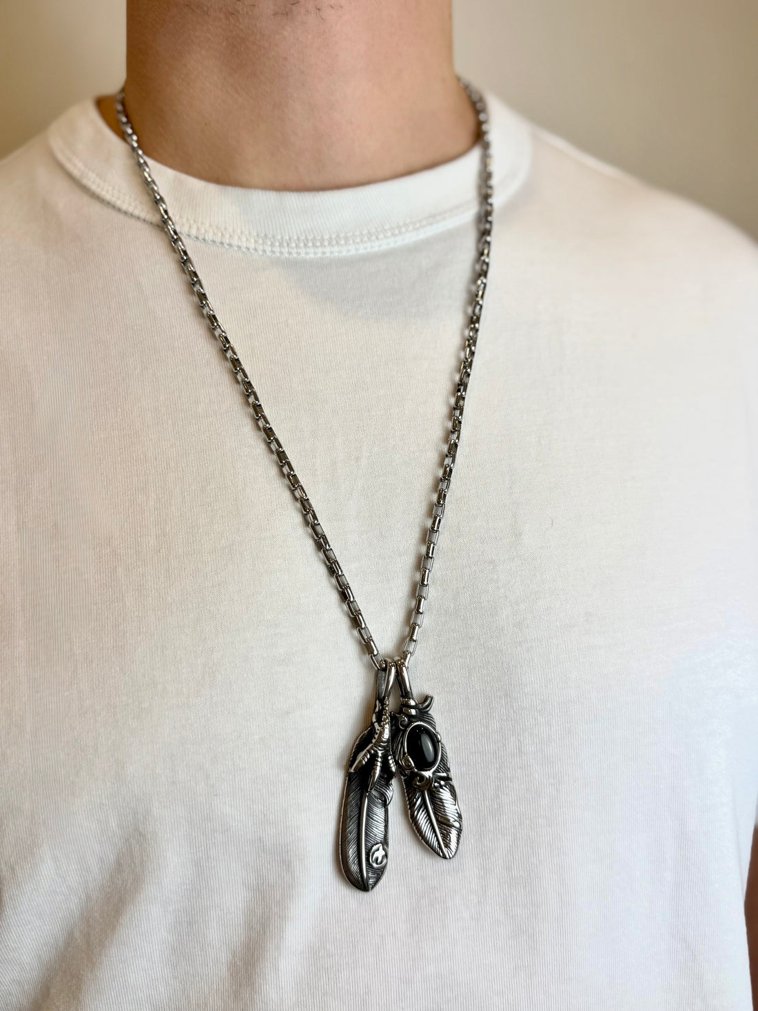 Grandinėlė su dviem plunksnomis ir varnos koja