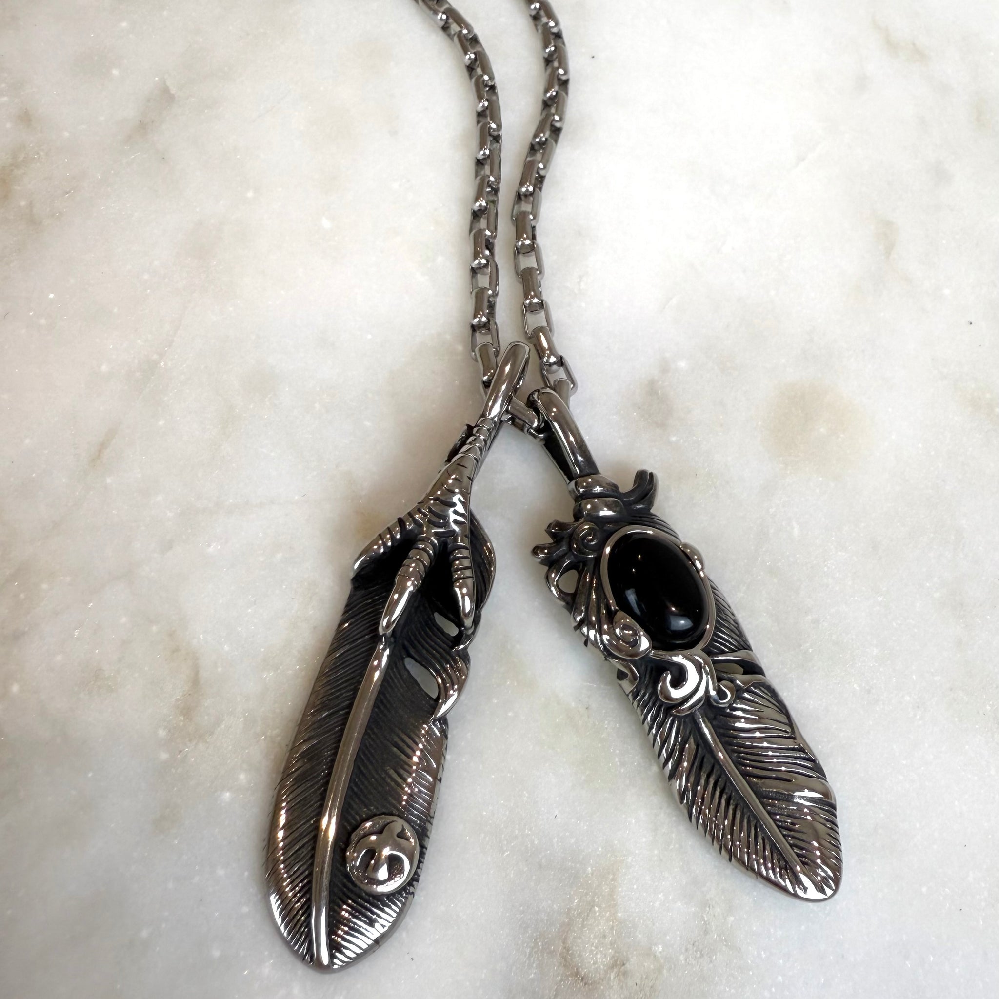 Grandinėlė su dviem plunksnomis ir varnos koja