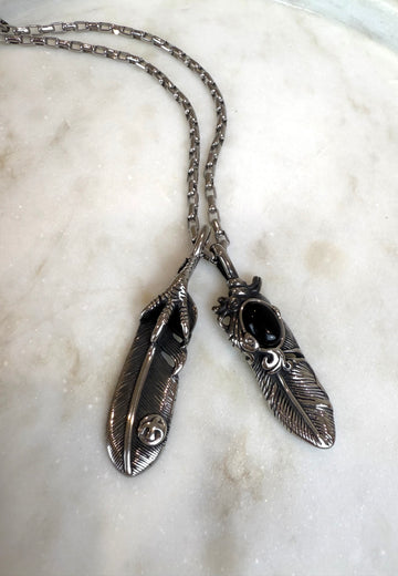 Grandinėlė su dviem plunksnomis ir varnos koja